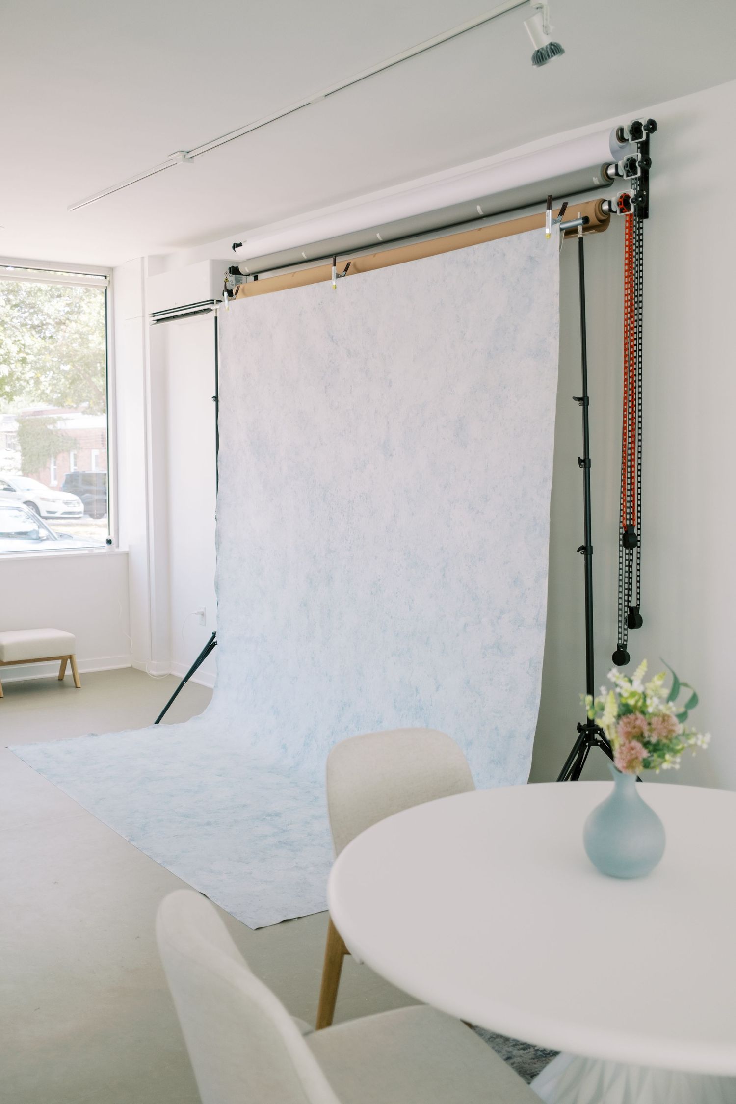 Minimalist photography studio setup with white backdrop and natural lighting from window showing six sequential angles.