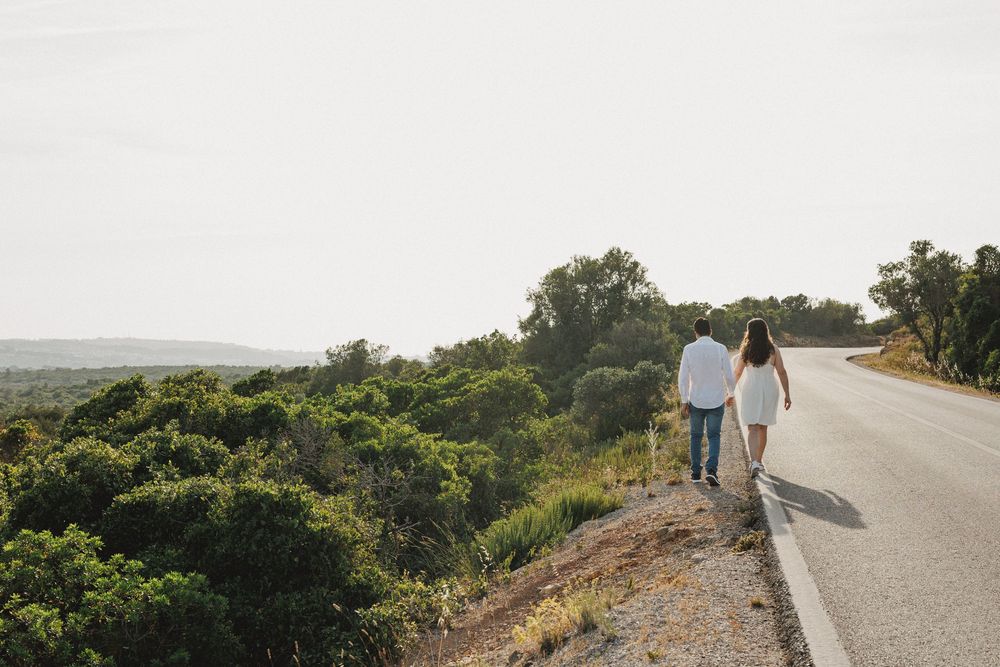 Pre-wedding photos in Setúbal – couple walking along a quiet road in Serra da Arrábida at golden hour in sesimbra