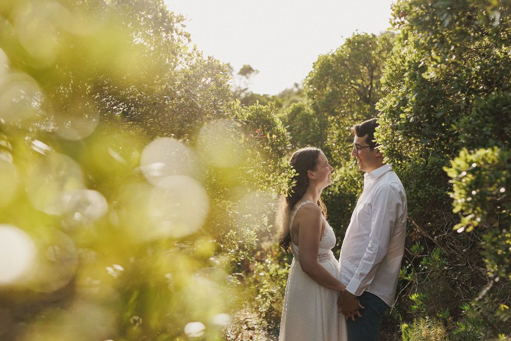 Romantic pre-wedding photos in Arrábida natural park with couple surrounded by green vegetation and soft sunlight