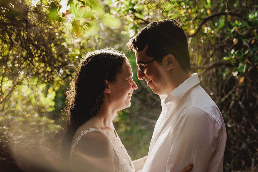 Close-up pre-wedding photo in Setúbal of couple smiling and holding each other in soft natural light