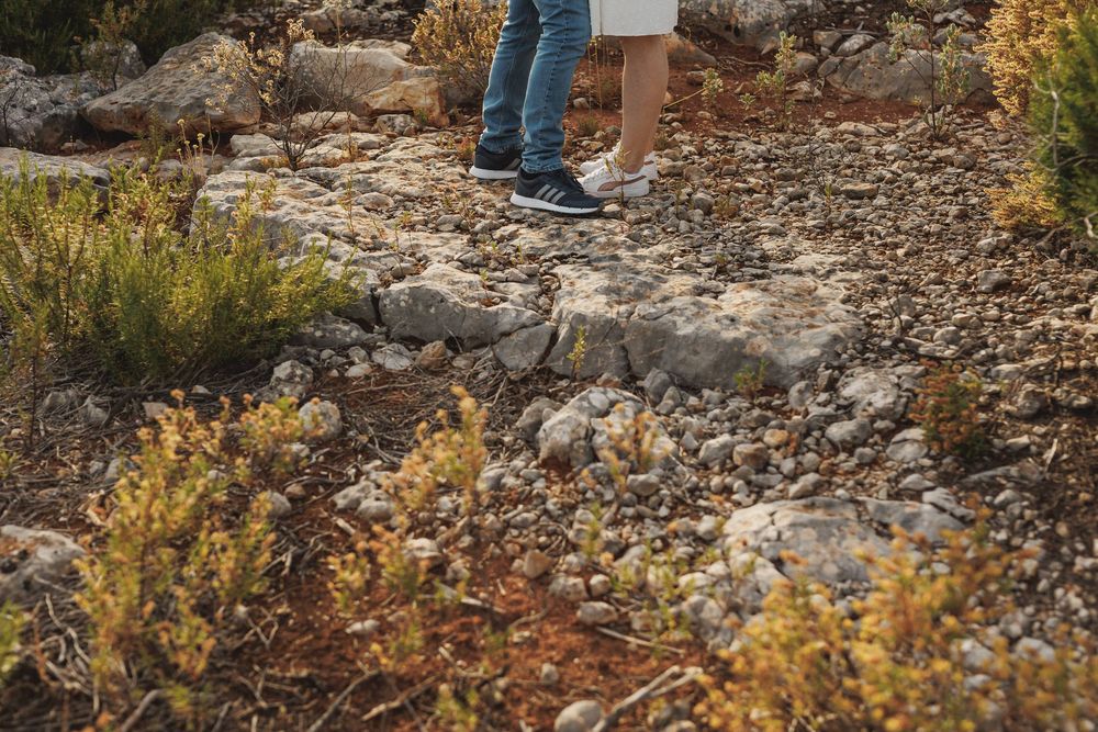Detail shot of couple’s feet walking on rocky ground during pre-wedding session in Arrábida natural park