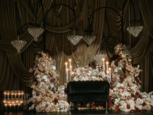 Elegant wedding venue decorated with crystal chandeliers and luxurious white floral arrangements.