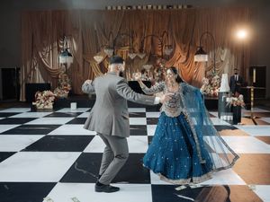 Couples dancing on a black and white checkered dance floor at an elegant wedding reception.