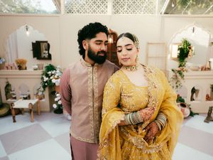 A wedding celebration featuring elegant decor with yellow and pink accents in a bright indoor venue.