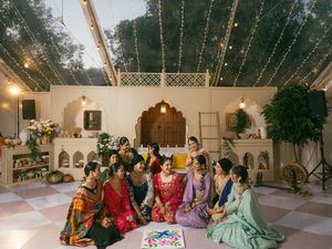 Wedding celebration in an outdoor venue with string lights and guests seated at long tables.