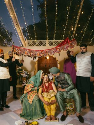 Wedding celebration under twinkling string lights with guests in traditional attire.