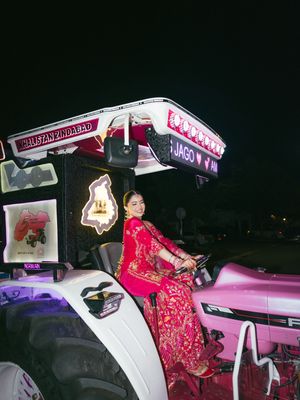 Decorated golf carts with illuminated signs lined up at night for a wedding celebration.
