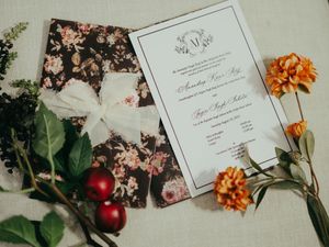 Wedding stationery and invitation cards styled with fresh flowers and fruit on a light background.