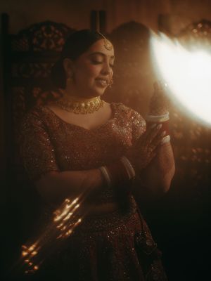 A series of moody, atmospheric shots featuring someone in a sparkling burgundy dress illuminated by dramatic backlighting.