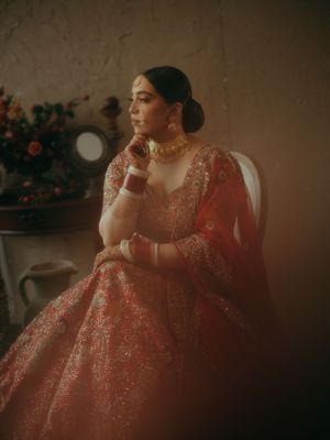 Dreamy portrait of someone wearing a sparkly coral-colored gown in moody lighting.