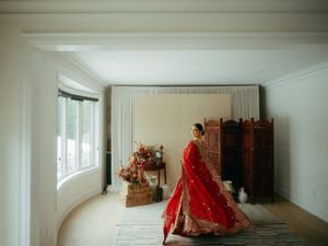 Panoramic view of a minimalist white room with traditional wedding decor and wooden elements.