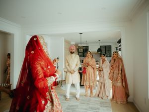 A collection of ornate wedding dresses and traditional attire displayed in a bright white room.