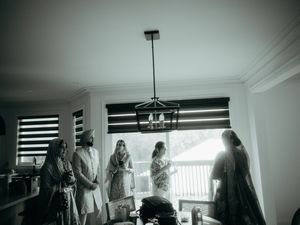 Wedding guests dancing and celebrating in an elegant indoor venue with modern lighting and decor.