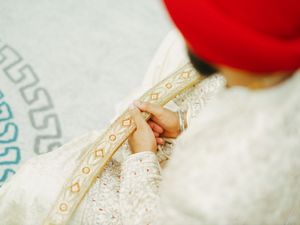 Close-up detail of intricate gold embroidery on traditional wedding attire.