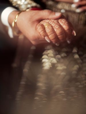 Close-up shots of hands with traditional wedding jewelry and henna designs.