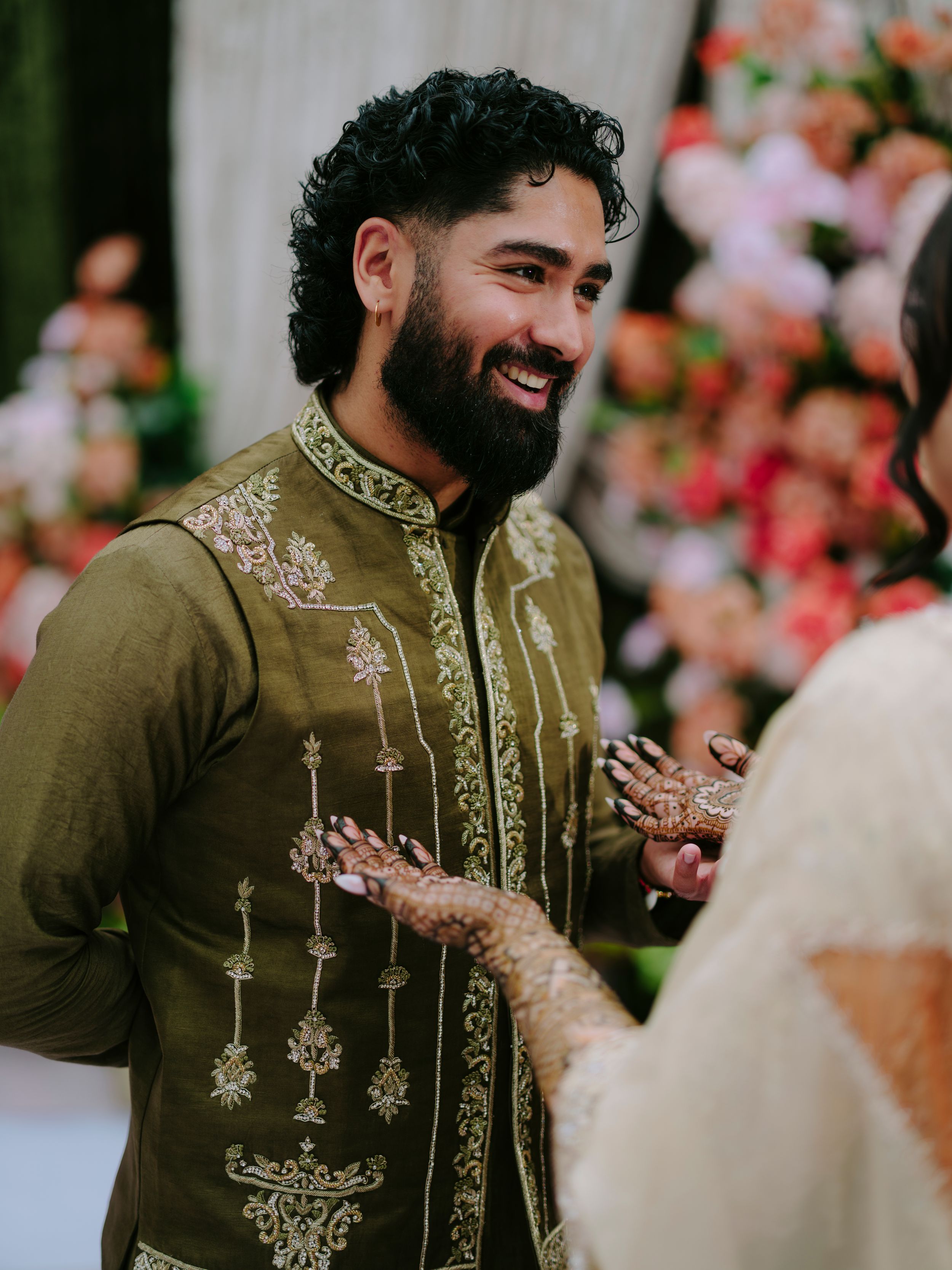 Traditional embroidered olive green wedding attire with detailed white threadwork design.