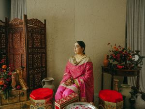 Traditional wedding preparation room with ornate screens and red accents.