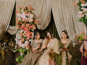 Elegant wedding stage decorated with draped fabric, floral arrangements, and soft peach color scheme.