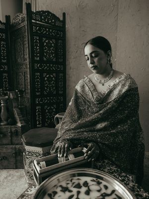 Traditional artisan working with detailed metalwork and decorative pieces in a workshop setting.