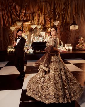 An elaborate embellished ballgown with intricate beadwork displayed on a fashion runway.