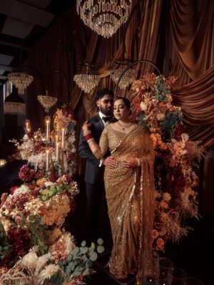 Elegant wedding setup with ornate floral arrangements, crystal chandeliers, and rich burgundy drapes creating a luxurious atmosphere.