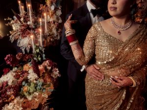 Elegant wedding scene with golden sequined dress, candlelit decor, and floral arrangements.