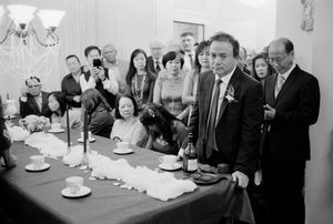 Wedding guests gathered around a decorated dining table during a formal Asian wedding reception.