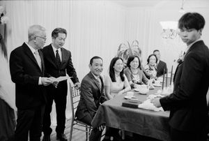 Family members and guests laughing together during a wedding signing ceremony indoors.