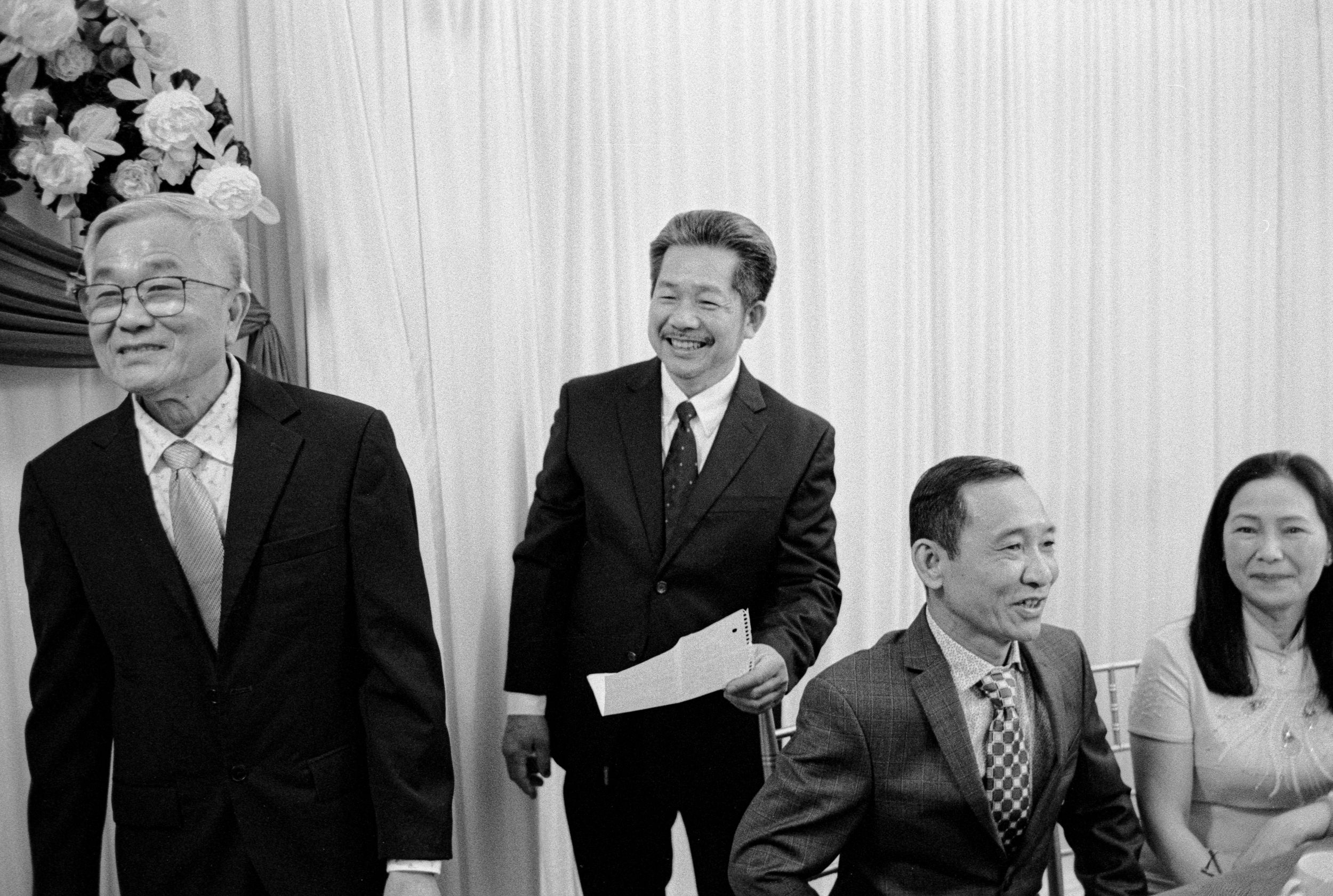 Smiling men in formal attire standing together during a wedding ceremony celebration.