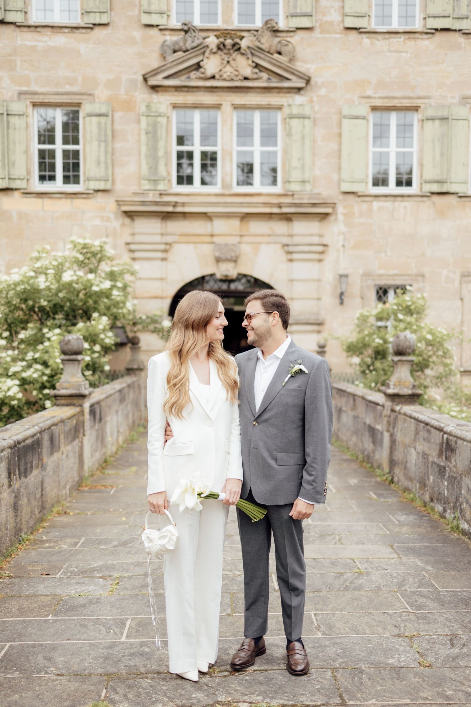 Bride and groom smile at each other outside of  beautiful standesamt building