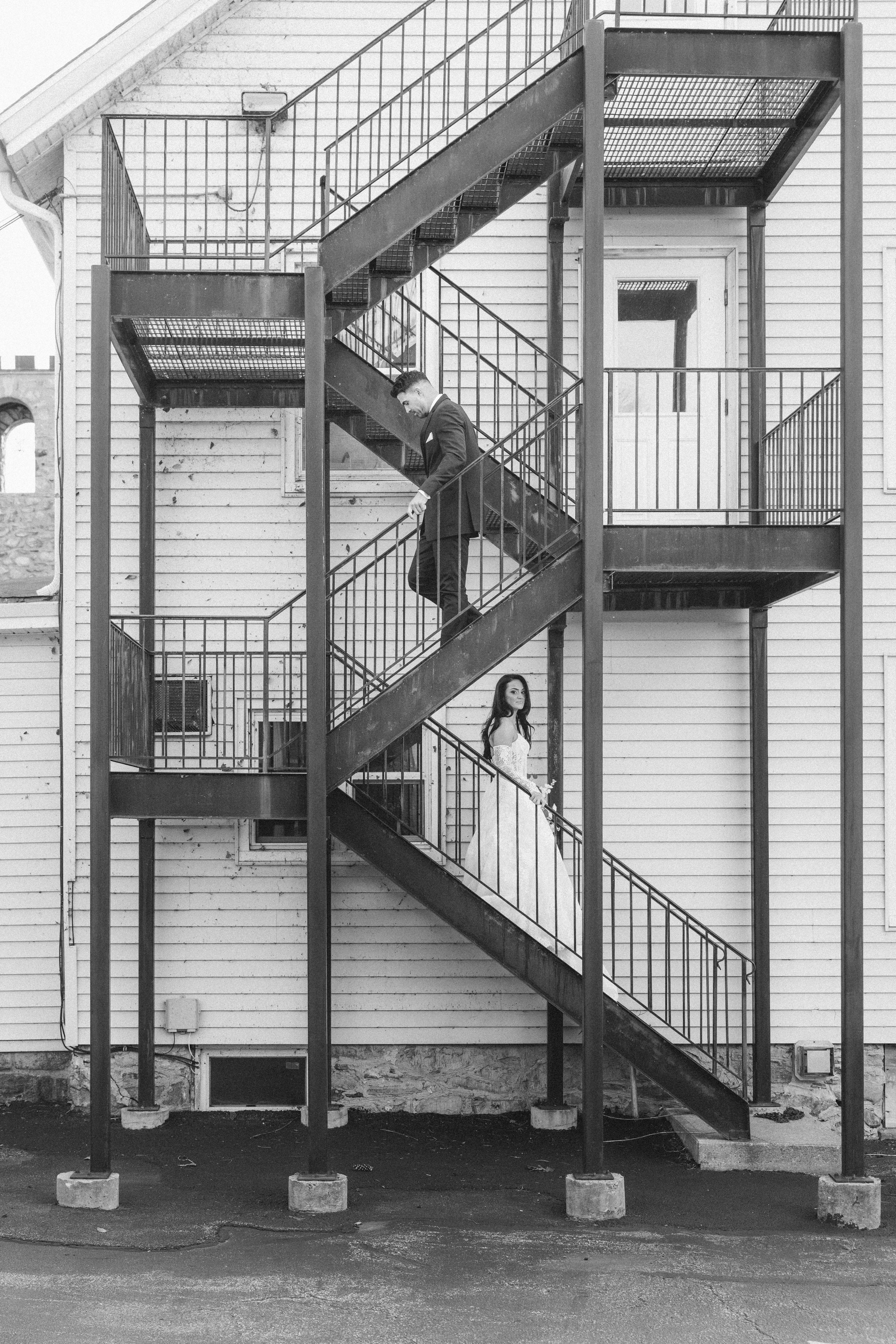 A series of black and white photographs showing a person descending an exterior metal staircase in progressive steps.