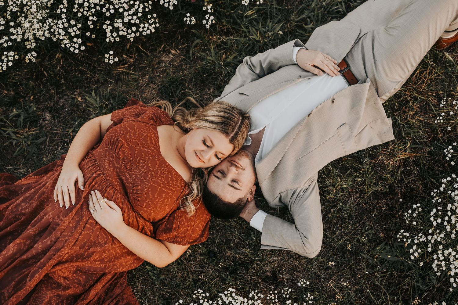 Flower Mound engagement photos in a wide open field with tiny white flowers at sunset.