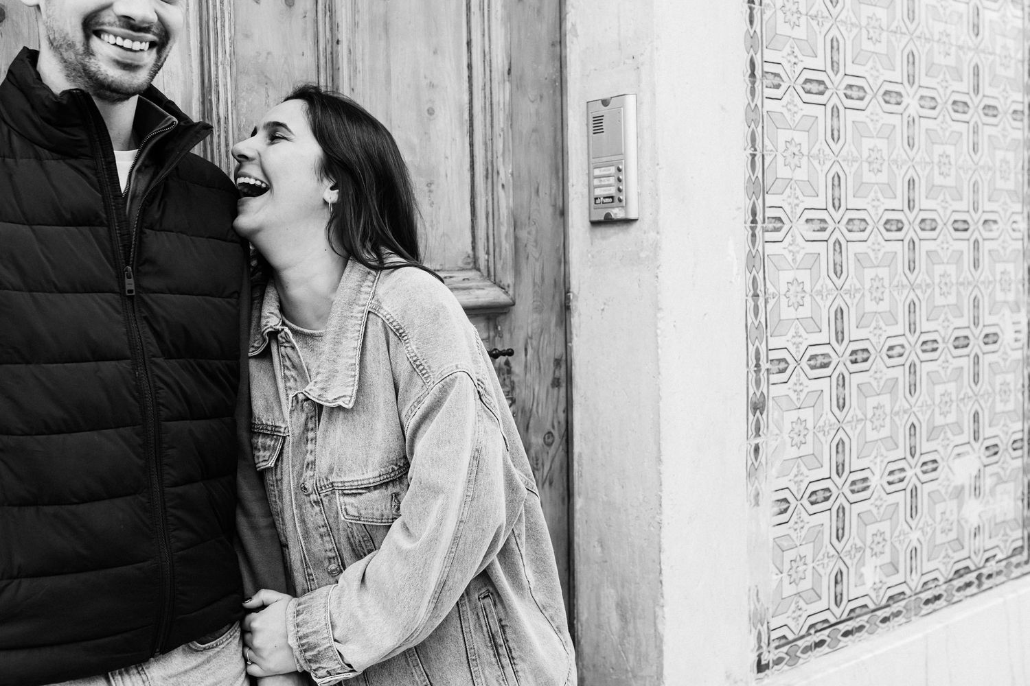 Black and white candid moment of couple laughing together during Lisbon pre wedding shoot in Baixa