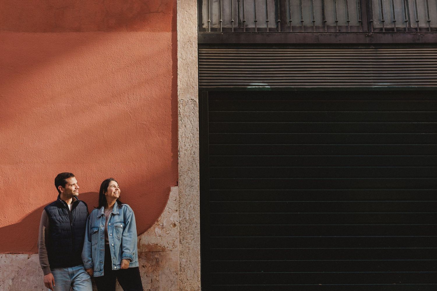 Intimate moment of couple hugging in front of blue tiled wall in Lisbon pre wedding photoshoot