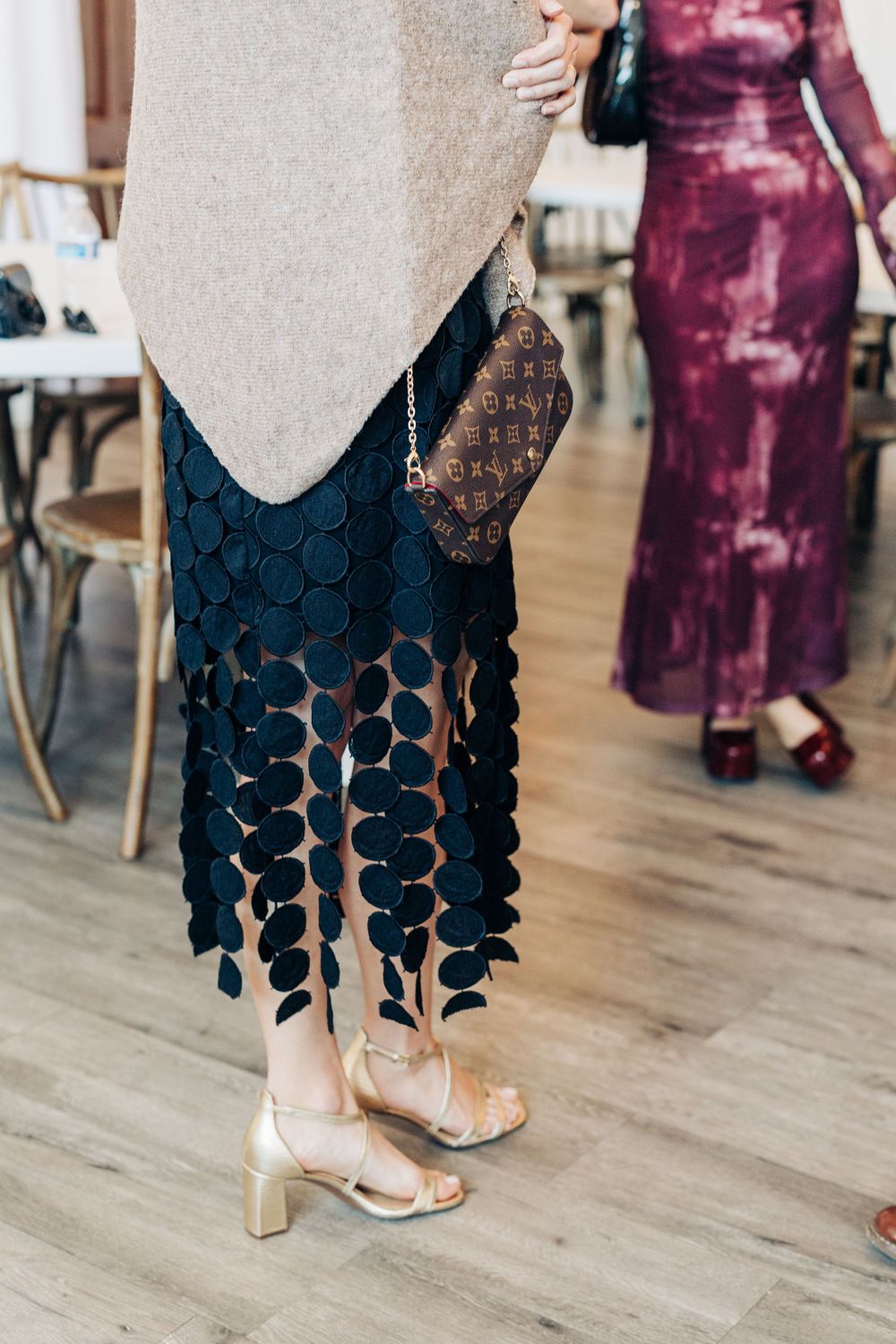 Close-up shots of formal dresses and shoes on a hardwood floor at an elegant event.