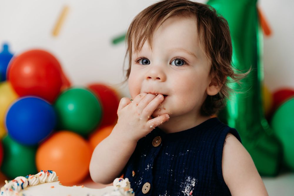Colorful birthday party setup with balloons and sprinkle decorations creates a festive celebration atmosphere.