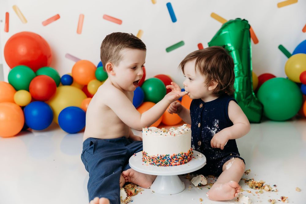 Birthday celebration scene with colorful balloons and decorative sprinkles against white background.