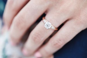 Close-up view of a sparkling diamond engagement ring shown from multiple angles on a person's hand.
