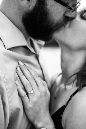Close up of a romantic couple sharing an intimate kiss in black and white.