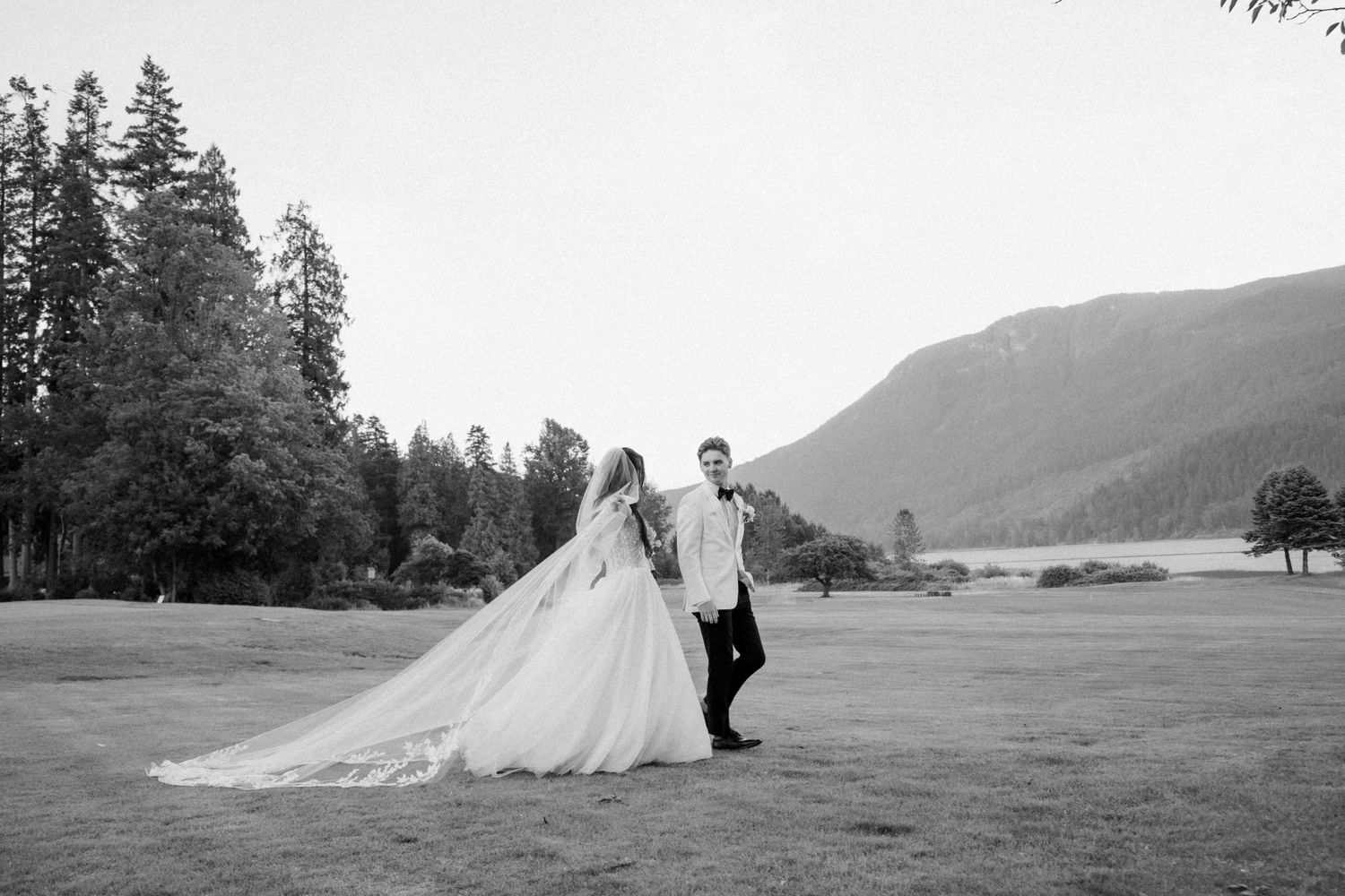 Couple poses in gothic archway with dramatic windows and natural light.