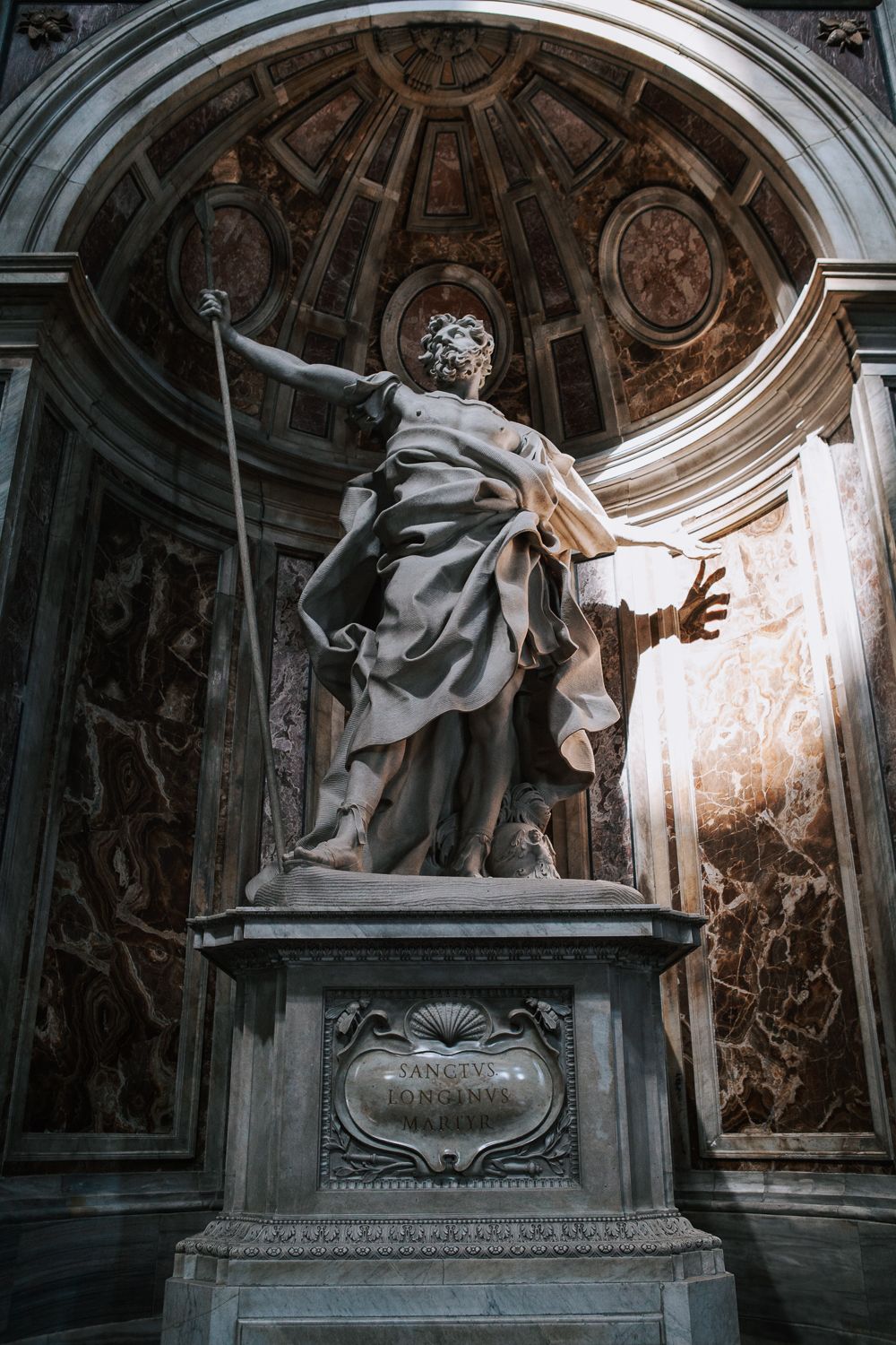 Marmorstatue des Heiligen Longinus von Bernini im Petersdom, dramatisch beleuchtet in einer prunkvollen Nische aus Marmor.