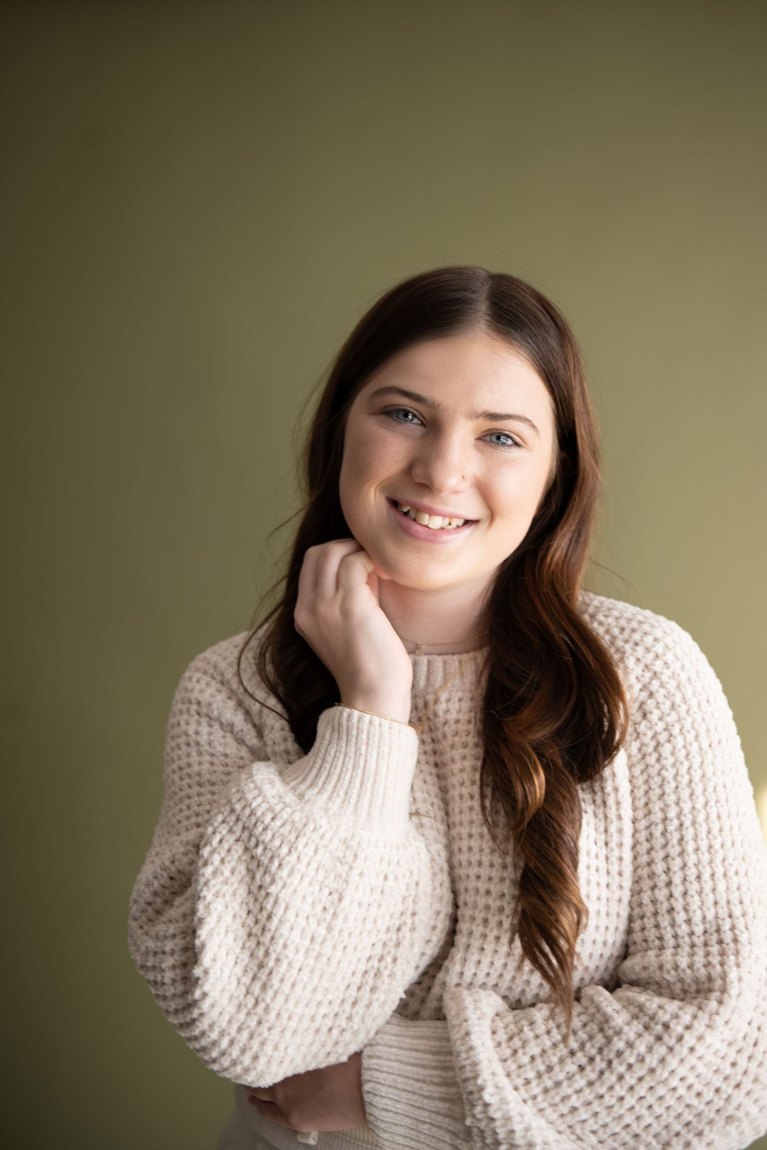 A series of photos showing someone wearing a cozy cream knit sweater against a neutral background.
