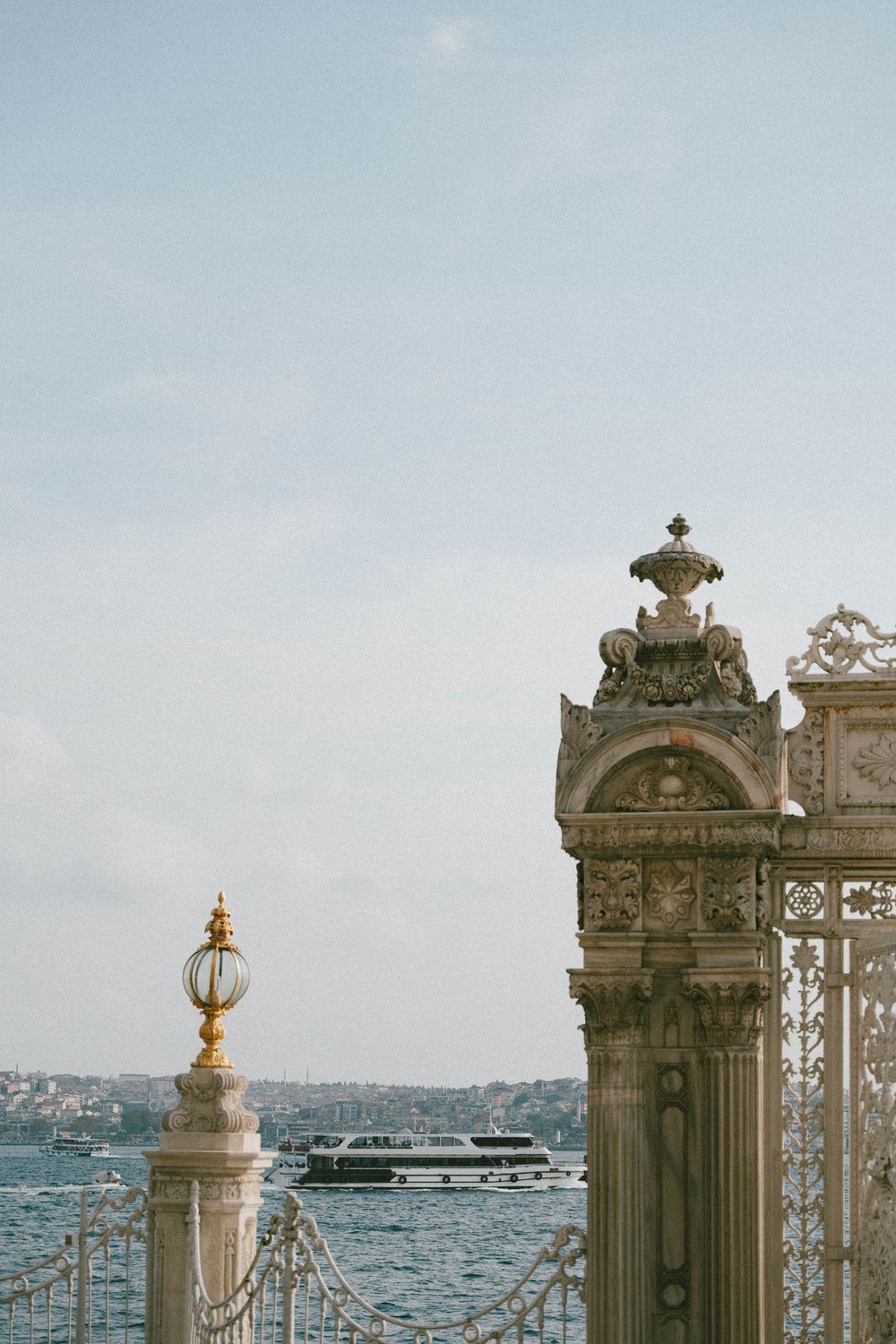 Ornate golden gate pillars of Dolmabahce Palace overlooking the Bosphorus strait in Istanbul, Turkey.
