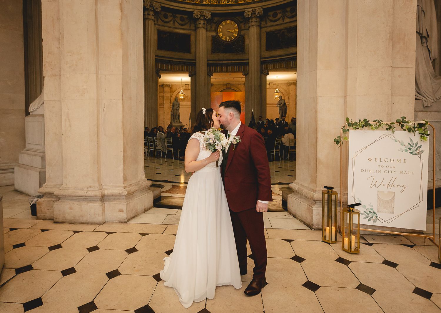 Bride and groom share romantic moment beside grand columns at Dublin City Hall wedding.