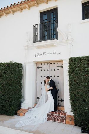 Wedding couple in elegant formal attire pose in sequence at entrance of Spanish colonial style building with white walls.