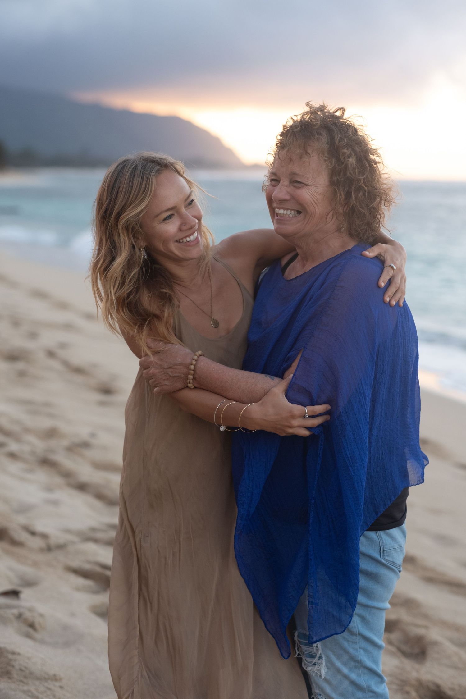 Mother and daughter sharing a joyful moment during a North Shore Oahu family photography session at sunset.