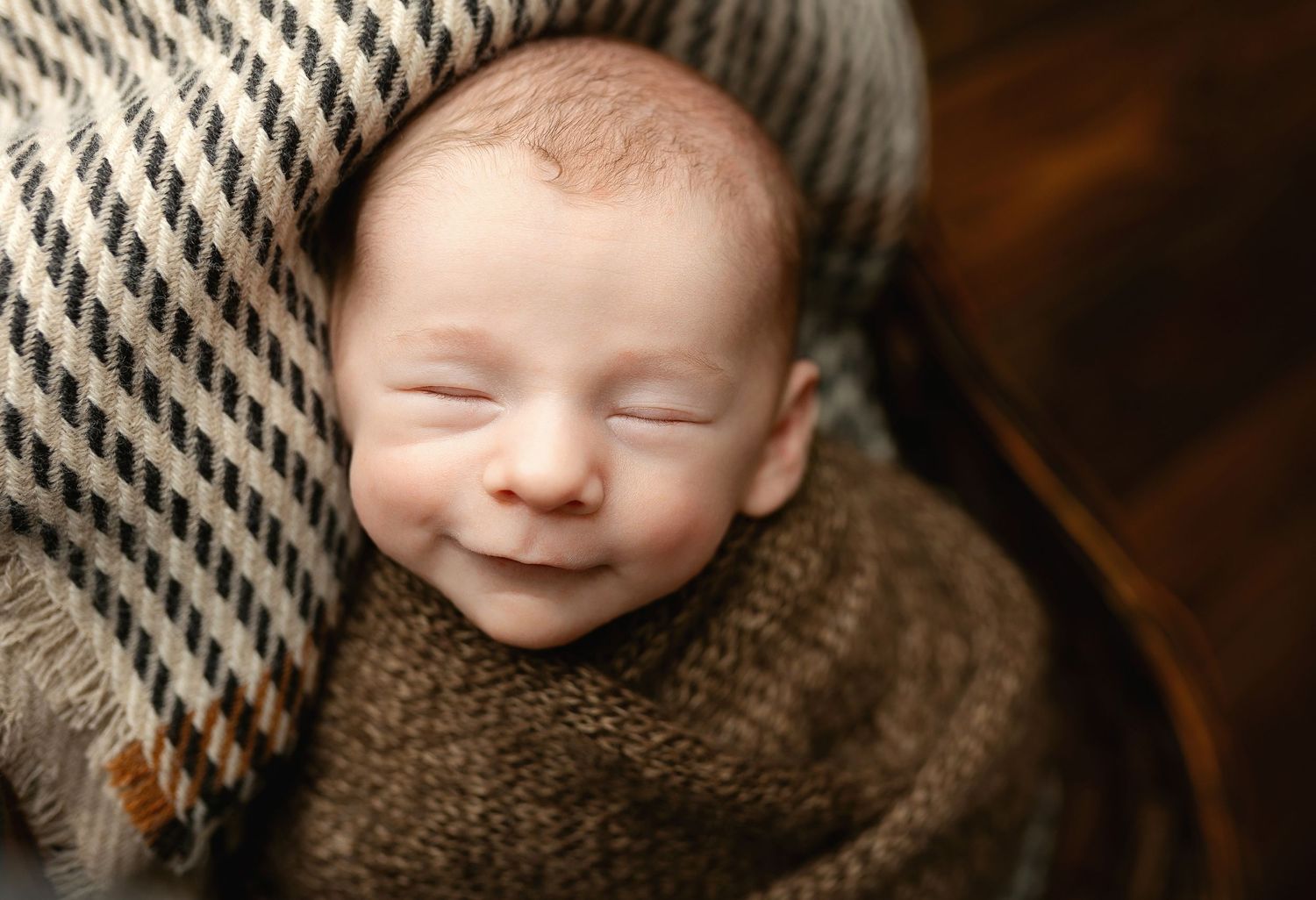 A newborn in brown is smiling. Greenville, SC newborn photographer, Easley SC newborn photographer, Upstate SC newborn photographer