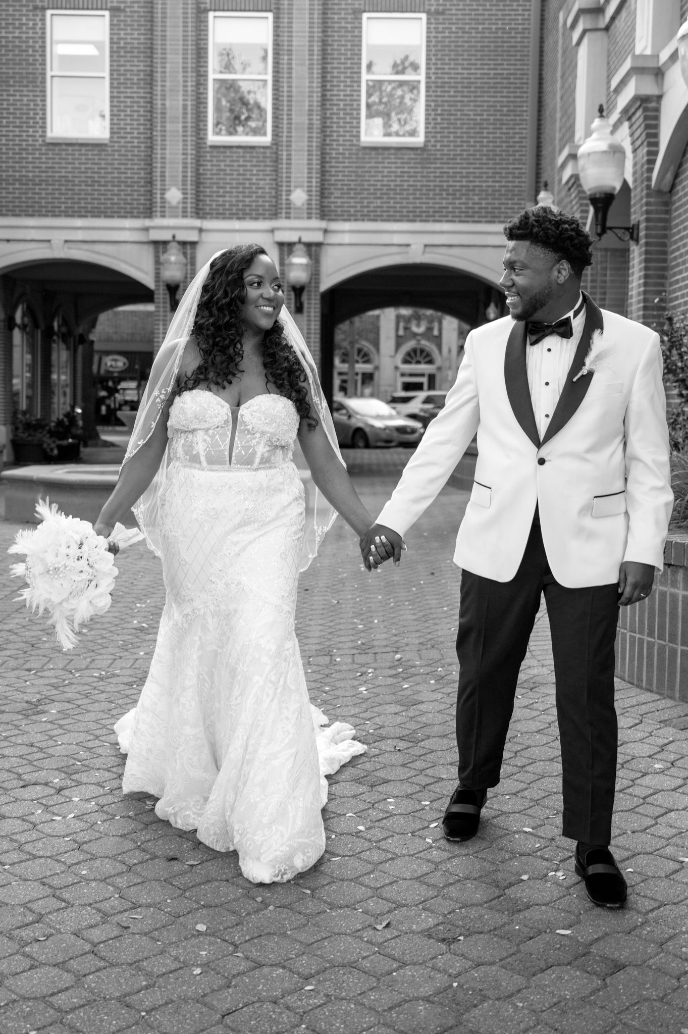 A series of romantic black and white wedding photos showing a couple sharing intimate moments on a brick pathway.