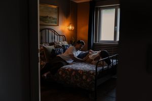 Dimly lit bedroom interior with warm ambient lighting and cozy bedding.