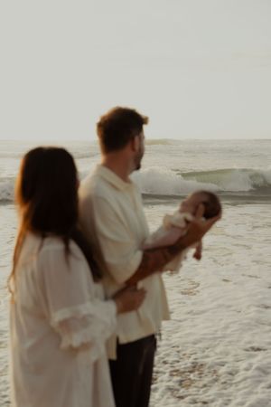 Family walking together on a beach during sunset.